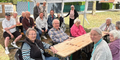 Krefeld: BewohnerInnen und Mitarbeitende sitzen zusammen bei Sommerfest.