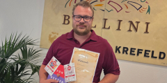Krefeld: Küchenleiter Dennis Heuvens hält Urkunde und Geschenke.