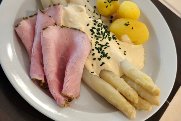 Krefeld: Spargel mit Schinken, Soße und Kartoffeln auf Teller.