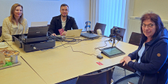 Krefeld: Mitarbeitende der Stadtverwaltung am Tisch mit Besucherin des Mobilen Bürgerbüros.