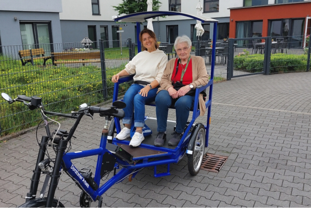 Dorsten: Mitarbeiterin und Bewohnerin sitzen in Rikscha.