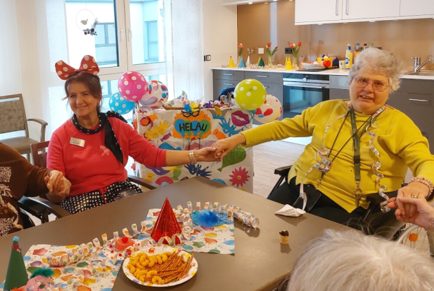 Dorsten: Mitarbeiterin und Bewohnerin vor Karnevalswagen.