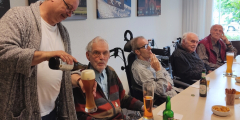 Krefeld: Mitarbeiter serviert Bewohnern Getränke.