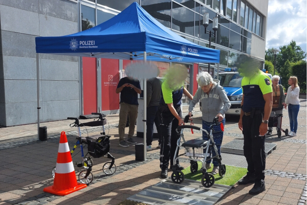 Dorsten: BewohnerIn mit Rollator neben PolizistInnen beim Rollatorparcours.
