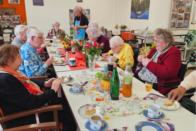 Krefeld: BewohnerInnen am Tisch beim Apfelkuchen-Essen.