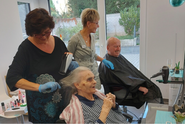Neuwied: Mitarbeitende frisieren BewohnerInnen im Friseursalon.