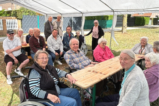 Krefeld: BewohnerInnen und Mitarbeitende sitzen zusammen bei Sommerfest.