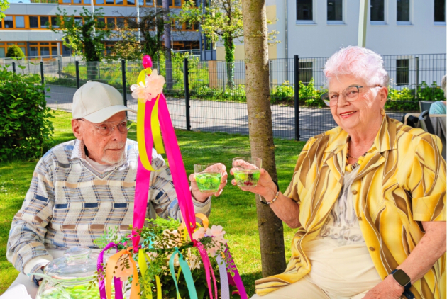 Neuwied: BewohnerInnen stoßen draußen mit Maibowle an.