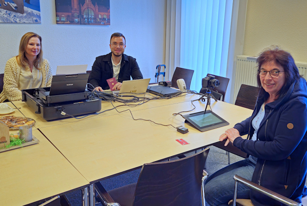 Krefeld: Mitarbeitende der Stadtverwaltung am Tisch mit Besucherin des Mobilen Bürgerbüros.