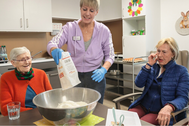Neuwied: Bewohnerinnen und Mitarbeiterin bereiten Teig für Osterzopf vor.