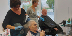 Neuwied: Mitarbeitende frisieren BewohnerInnen im Friseursalon.